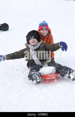 Due giovani ragazzi godetevi piste per slittino a Prospect Park di Brooklyn, New York. Foto Stock