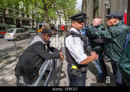 Brustchom Ziamani (L) ha raffigurato il 9 maggio 2014 fuori dall'alta Commissione indiana a Londra durante una protesta islamista con i primi nazionalisti britannici incluso Paul Golding opponente (R). Brustchom Ziamani, 19 anni, è stato rimandato in custodia dopo essere comparso in tribunale per affrontare accuse di terrore. Ziamani, di Camberwell, a sud-est di Londra, è stato accusato di 'intraprendere una condotta in preparazione di atti terroristici' il 19 agosto 2014 o prima. Il signor Ziamani è stato arrestato martedì 19 agosto 2014 nella zona est di Londra. Attualmente è in fase di processo presso l'Old Bailey Court. Foto Stock