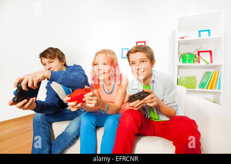 Ragazze e ragazzi con joystick per la riproduzione di una console di gioco Foto Stock