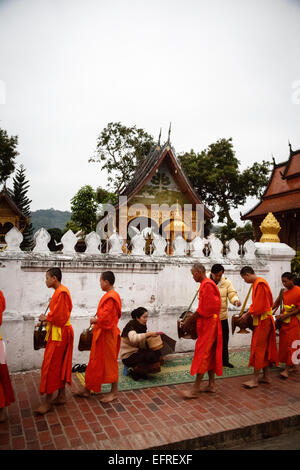 I monaci raccogliendo elemosine al sunrise, Luang Prabang, Laos. Foto Stock