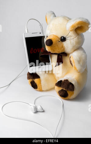 Orsacchiotto di peluche congratulazioni Valentines tramite telefono. Foto Stock