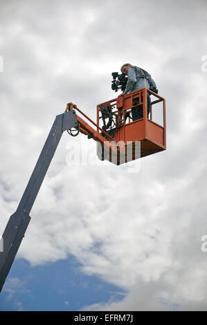 Cameraman usando un cherry picker sulla posizione Foto Stock