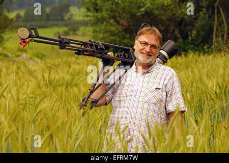 Cameraman al lavoro in un campo di grano Foto Stock