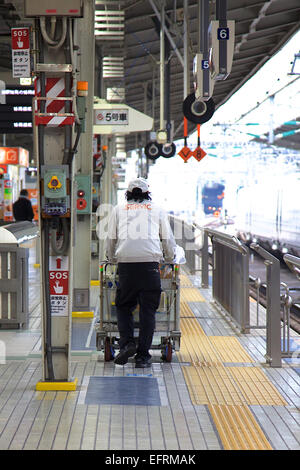 Osaka, JP - 21 Gennaio 2015 : un pulitore spinge un contenitore di rifiuti presso la piattaforma dei treni nella stazione di Shin Osaka. (Foto di Rodrigo Reyes Marin/AFLO) Foto Stock