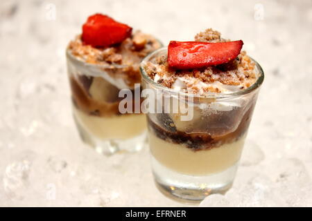 Banoffee pie in un mini vetro, versato con caremel e panna montata, deliziosi dessert. Foto Stock