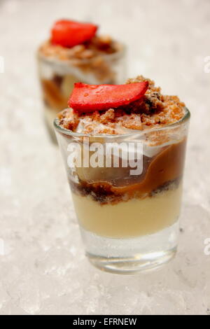 Banoffee pie in un mini vetro, versato con caremel e panna montata, deliziosi dessert. Foto Stock