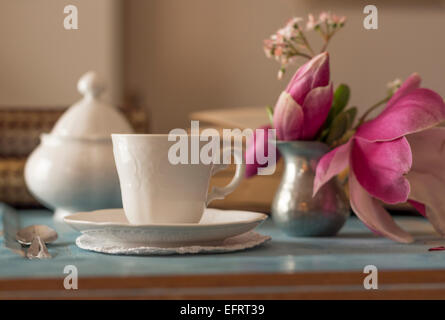 Una bella tazza di caffè e un libro aperto su un tavolo di legno Foto Stock