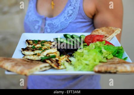 Grigliata di formaggio halloumi servito con olive verdura e pane pita. Foto Stock