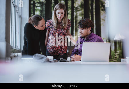 Colpo di giovane team di progettisti discutendo magazine pubblicazione. Il team creativo di pianificazione per un nuovo progetto di business. Foto Stock