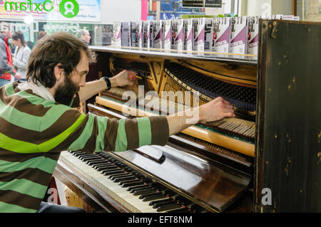 Il pianista Matthew Bourne svolge un pianoforte da suonare le corde con le sue dita. Foto Stock