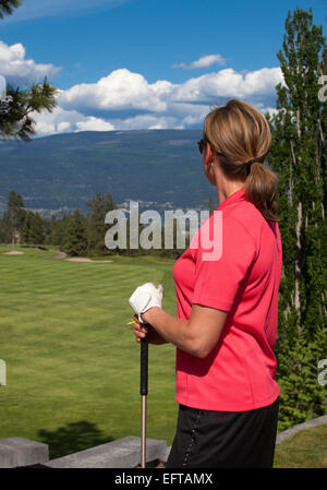 Foto all'aperto del giocatore di golf femminile guardando il campo da golf, rivolta lontano dalla telecamera. Foto Stock