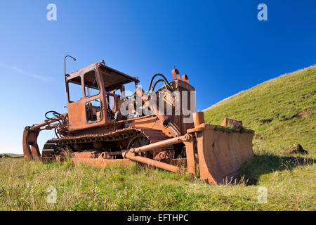 Arrugginita derelitti bulldozer contro un perfetto cielo blu Foto Stock