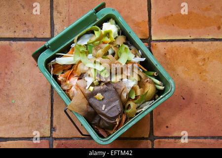 Il compost la benna riempita con bucce, filtri per caffè, ecc. su un piano cucina Foto Stock