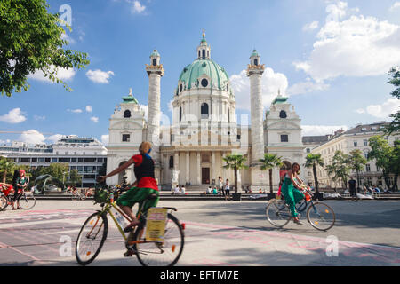 I ciclisti dalla barocca Karlskirche, a Vienna, in Austria Foto Stock