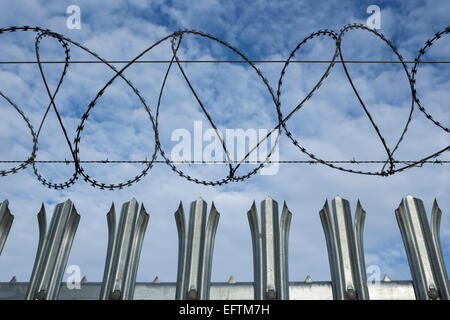 Acciaio filo di rasoio recinzioni perimetrali. Foto Stock