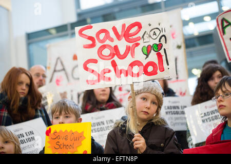 Aberystwyth, Wales, Regno Unito. Il 10 febbraio, 2015. 'Salva la nostra scuola' : i genitori e i bambini a protestare presso gli uffici di Ceredigion County Council in Aberystwyth contro la proposta di chiusura di due piccole scuole primarie. Le scuole, Cwmpadarn e Llangynfelyn, vicino a Aberystwyth, entrambi sono stati stanziati per la chiusura da parte di un comitato di riesame delle autorità locali a causa della caduta dei numeri della pupilla Photo credit: keith morris / alamy live news Foto Stock