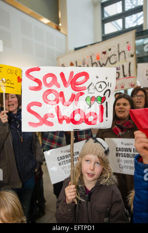 Aberystwyth, Wales, Regno Unito. Il 10 febbraio, 2015. 'Salva la nostra scuola' : i genitori e i bambini a protestare presso gli uffici di Ceredigion County Council in Aberystwyth contro la proposta di chiusura di due piccole scuole primarie. Le scuole, Cwmpadarn e Llangynfelyn, vicino a Aberystwyth, entrambi sono stati stanziati per la chiusura da parte di un comitato di riesame delle autorità locali a causa della caduta dei numeri della pupilla Photo credit: keith morris / alamy live news Foto Stock