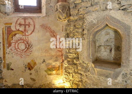 Italia Friuli M.B. Pulfero in provincia di Udine la Grotta di San Giovanni d'Antro. Cappella di San Giovanni Battista ed Evangelista, sulla parete dipinti a fresco con rappresentazione di palme, soli a raggi uncinati, croci nel cerchio delle Nazioni Unite e in alto la figura di suonatore di cornamusa | Italia Friuli Venezia Giulia Antro un villaggio nei pressi di Pulfero in provincia di Udine la Chiesa della Grotta di San Giovanni d'Antro Affresco nella Cappella di San Giovanni Evangelista Foto Stock