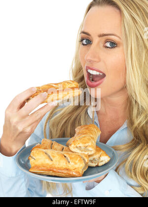 Fiducioso positivo felice giovane donna con pane appena sfornato salato rotoli di salsiccia isolata contro uno sfondo bianco con un tracciato di ritaglio e spazio di copia Foto Stock