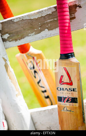 Ritagliato colpo di mazze da cricket appoggiata contro la recinzione imbiancate Foto Stock