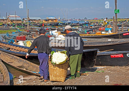 Barche aperte al villaggio sul lago con le tradizionali case in legno su palafitte in Lago Inle, Nyaungshwe, Stato Shan, Myanmar / Birmania Foto Stock