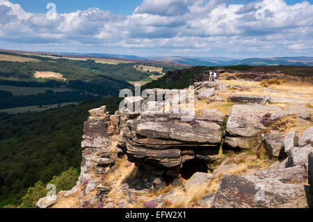 La luce del sole sul bordo Curbar nel Peak District. Una piccola grotta sul bordo. Foto Stock