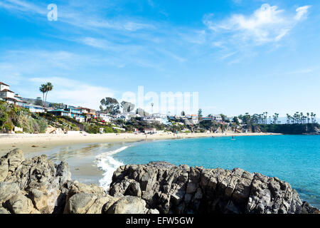 Una vista di una spiaggia appartata baia anteriore mostra belle acque turchesi che fiancheggiano la riva sabbiosa in Laguna Beach in California Foto Stock