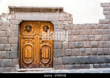 Inca muratura in pietra con un bel legno intagliato porta in Cusco, Perù Foto Stock