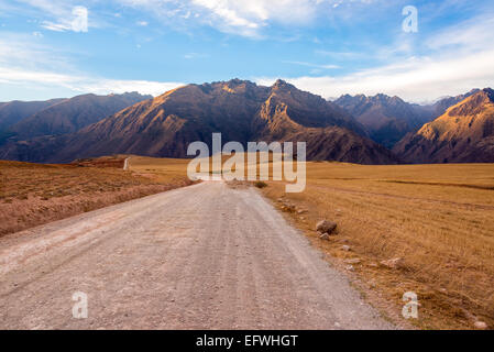 Strada sterrata con le montagne delle Ande in aumento dello sfondo nella Valle Sacra vicino a Cusco, Perù Foto Stock