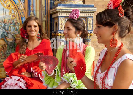 La fiera di Siviglia Feria de Abril Sevilla Fiera di Primavera tre amici in abiti di Flamenco Sevillanas Fans abito tradizionale femminile Foto Stock