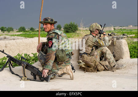 Una delle forze speciali degli Stati Uniti soldato e di un esercito nazionale afghano commando dal 3° Commando Kandak veglia per talebani insorti durante un villaggio operazione di compensazione 16 maggio 2012 nel villaggio di Gerandai, Panjwai distretto, provincia di Kandahar, Afghanistan. Foto Stock
