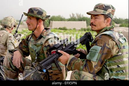 Esercito Nazionale Afghano commandos dal 3° Commando Kandak e dalle forze speciali americane soldato continua a guardare per talebani insorti durante un villaggio operazione di compensazione 16 maggio 2012 nel villaggio di Gerandai, Panjwai distretto, provincia di Kandahar, Afghanistan. Foto Stock