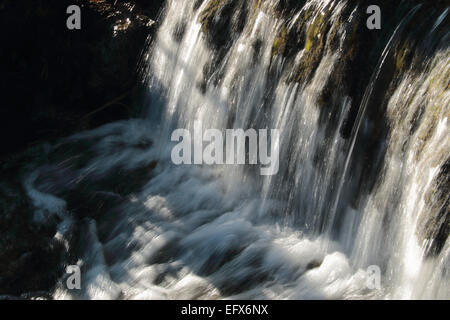 Flusso di spumanti e cascata che scorre attraverso il villaggio Foto Stock