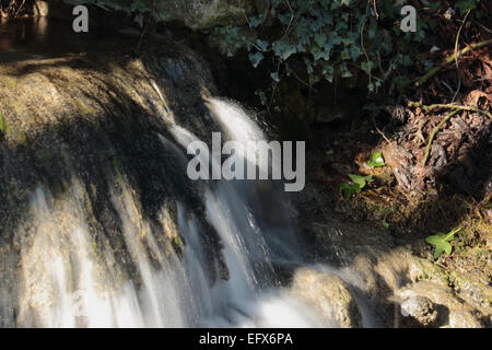 Flusso di spumanti e cascata che scorre attraverso il villaggio Foto Stock