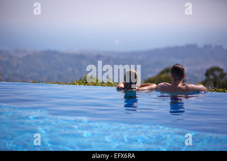Coppia in vacanza in piscina a sfioro nel sud della Francia guardando la Cote d Azur visualizza Foto Stock