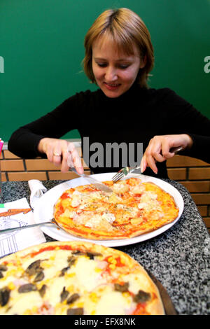 Immagine del ritratto del simpatico giovane donna in pizzeria Foto Stock