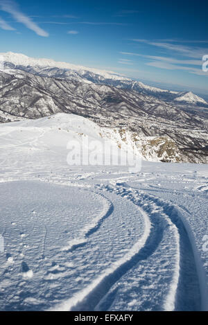 Il free ride piste da sci sul pendio nevoso. Colpo obliquo prelevate al di sopra delle Alpi italiane. Vecchia Stazione sciistica ora utilizzato per paese indietro Foto Stock