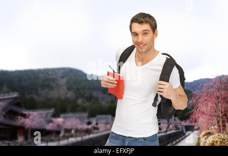 Felice giovane con zaino e prenota il viaggio Foto Stock