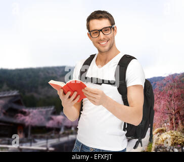 Felice giovane con zaino e prenota il viaggio Foto Stock