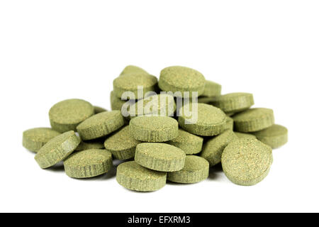 Un mucchio di supplemento nutrizionale con spirulina (alghe verdi) C-vitamina compresse / pillole. Isolato su sfondo bianco. Foto Stock