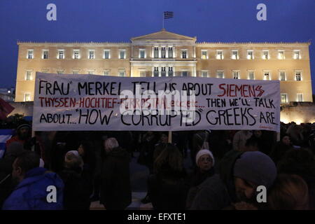 Atene, Grecia. Xi Febbraio 2015. Un grande striscione vola al di fuori del parlamento greco, lettura "Frau Merkel, ci raccontano di Siemens ... etc e poi parleremo di come corrotto greci sono". Migliaia di greci hanno protestato ad Atene in piazza Syntagma di fronte al parlamento greco a sostegno del governo greco in anticipo della cruciale Eurogruppo incontro che si intendono, per forzare la Grecia in una prosecuzione della politica di austerità. Credito: Michael Debets/Alamy Live News Foto Stock