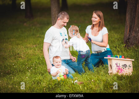 La famiglia felice con scatola di nidificazione e vernici Foto Stock