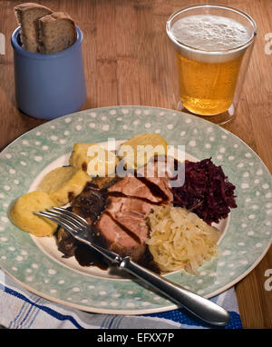 Slow arrosto di maiale con il rosso e bianco i crauti e gli gnocchi di patate Foto Stock