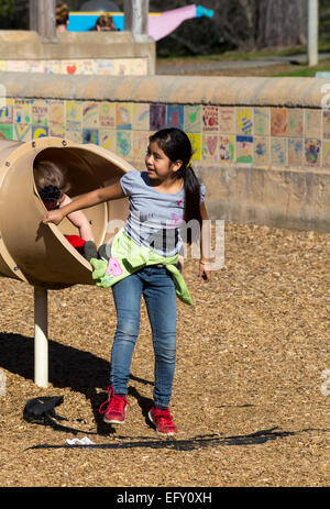 Ragazza ispanica, ragazza, ragazza, slitta tubolare, parco giochi, Pioneer Park, Novato, California, Stati Uniti, America del Nord Foto Stock