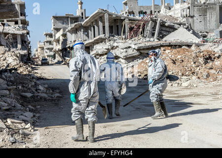 Kobane, Siria. 6 febbraio, 2015. Una unità di curdi YPG fighters indossare tute di protezione come cercare le strade per corpi morti e cadaveri nelle rovine di Kobane, Siria, 6 febbraio 2015. I recenti scontri tra i combattenti curdi e i combattenti del cosiddetto Stato islamico (SI) ha lasciato vaste aree della città di Kobane in rovine. Foto: Sebastian Backhaus/dpa - nessun filo SERVICE -/dpa/Alamy Live News Foto Stock