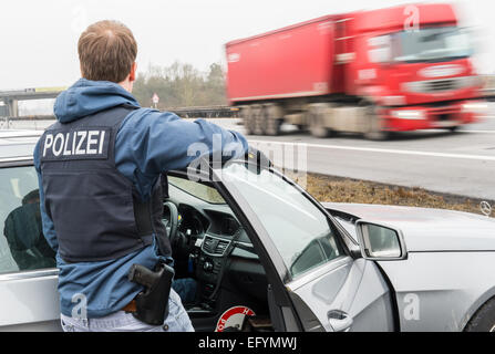 Passau, Germania. 12 Feb, 2015. Un ufficiale tedesco di polizia federale conduce un arresto e controllare la ricerca sull'autostrada A3 nei pressi di Passau, Germania, 12 febbraio 2015. Lo Stato di Baviera ha deciso di intensificare il suo punto di arresto e delle operazioni di ricerca a causa del numero sempre crescente di richiedenti asilo provenienti dal Kosovo. Foto: Marc Mueller/dpa/Alamy Live News Foto Stock