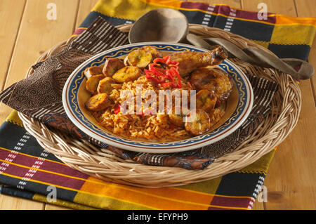 Jollof di riso con pollo fritto e piantaggine. Foto Stock