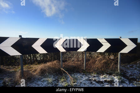 I simboli a frecce sulla curva stretta dei driver su strada di campagna Yorkshire Regno Unito Foto Stock