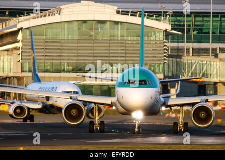 Aer Lingus Airbus A320 i taxi sulla pista 28 presso l'aeroporto di Dublino, come Ryanair Boeing 737-800 segue. Foto Stock