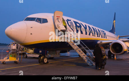 I passeggeri di salire a bordo di un Boing 737-800 di Ryanair a Londra Stansted Aeroporto la mattina presto. Foto Stock